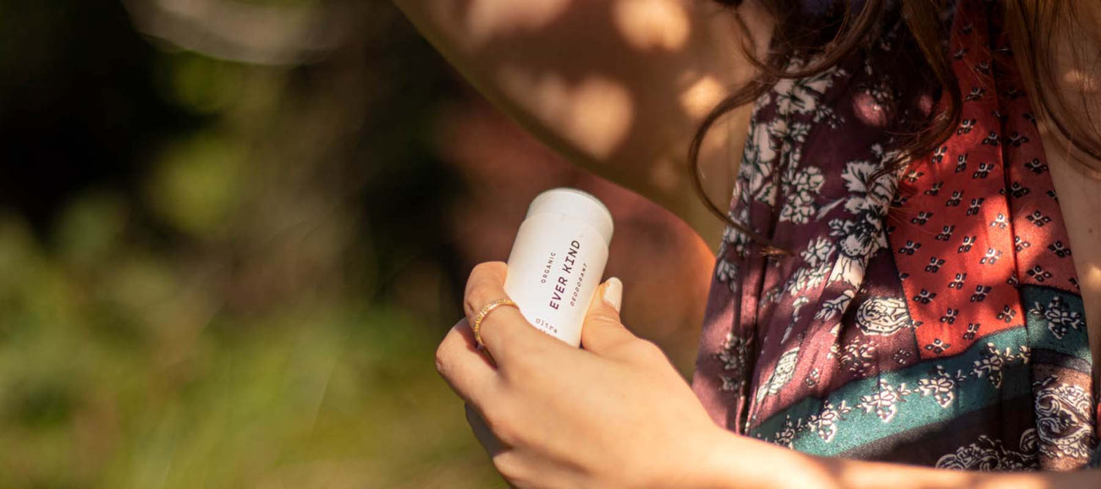 Applying Everkind organic natural deodorant outdoors as part of a daily bodycare ritual.