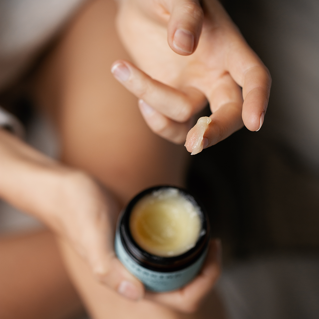 Woman cherishing her skin with Everkind Organic Body Balm. A fine fragrance oil that's bliss for body and mind.
