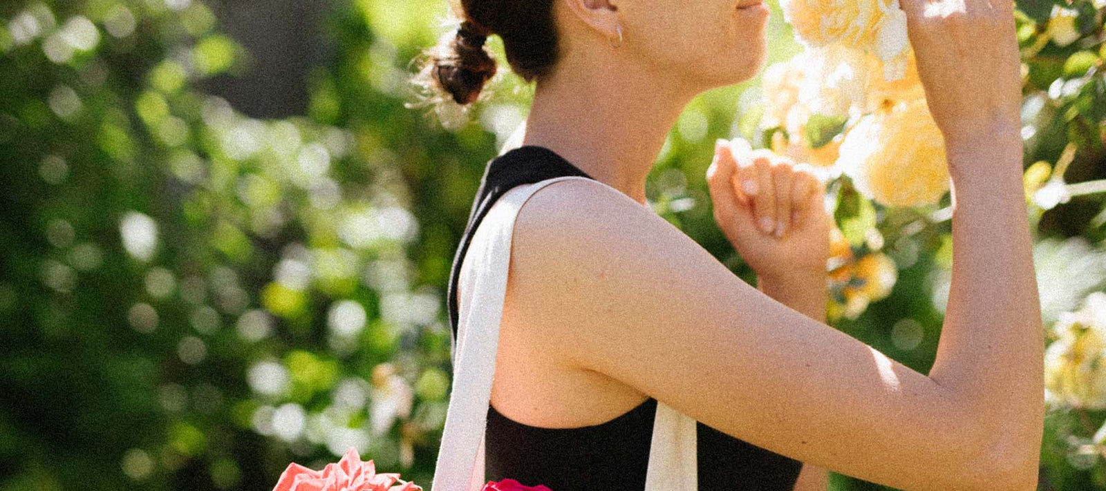 Women spending time in a rose garden and taking a moment to smell the roses.