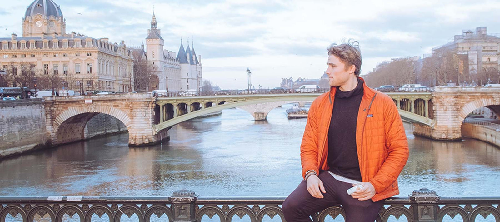 Man holding natural deodorant by a river in Paris, searching for the best natural deodorant for men that actually works.