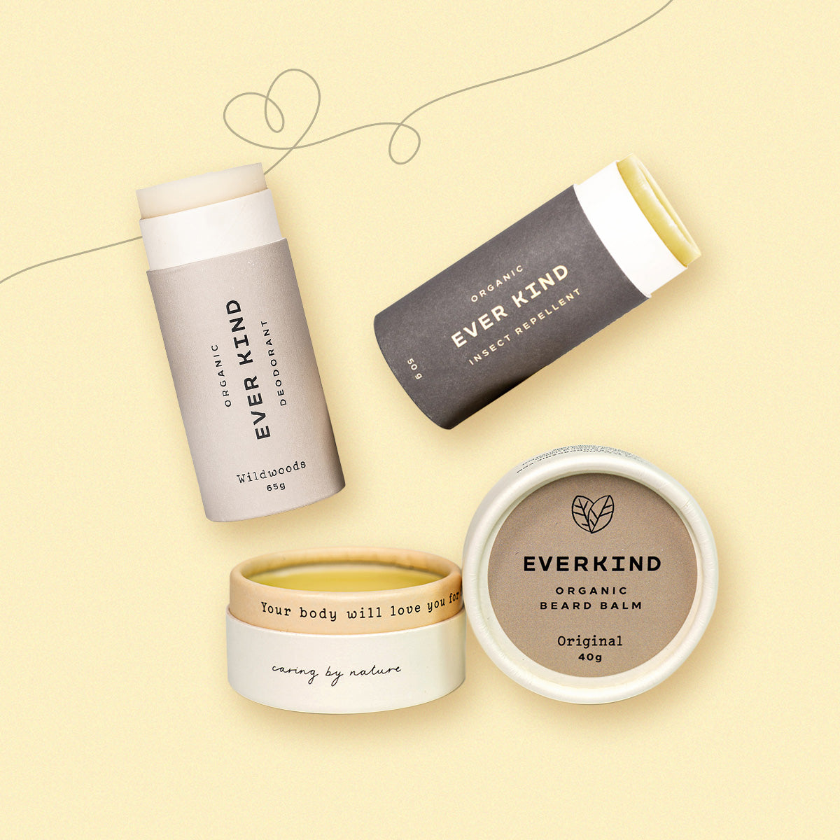 Flatlay of Everkind's Kind Man Kit, featuring Wildwoods deodorant, Insect Repellent, and Original Beard Balm, with hearts on a soft yellow background.