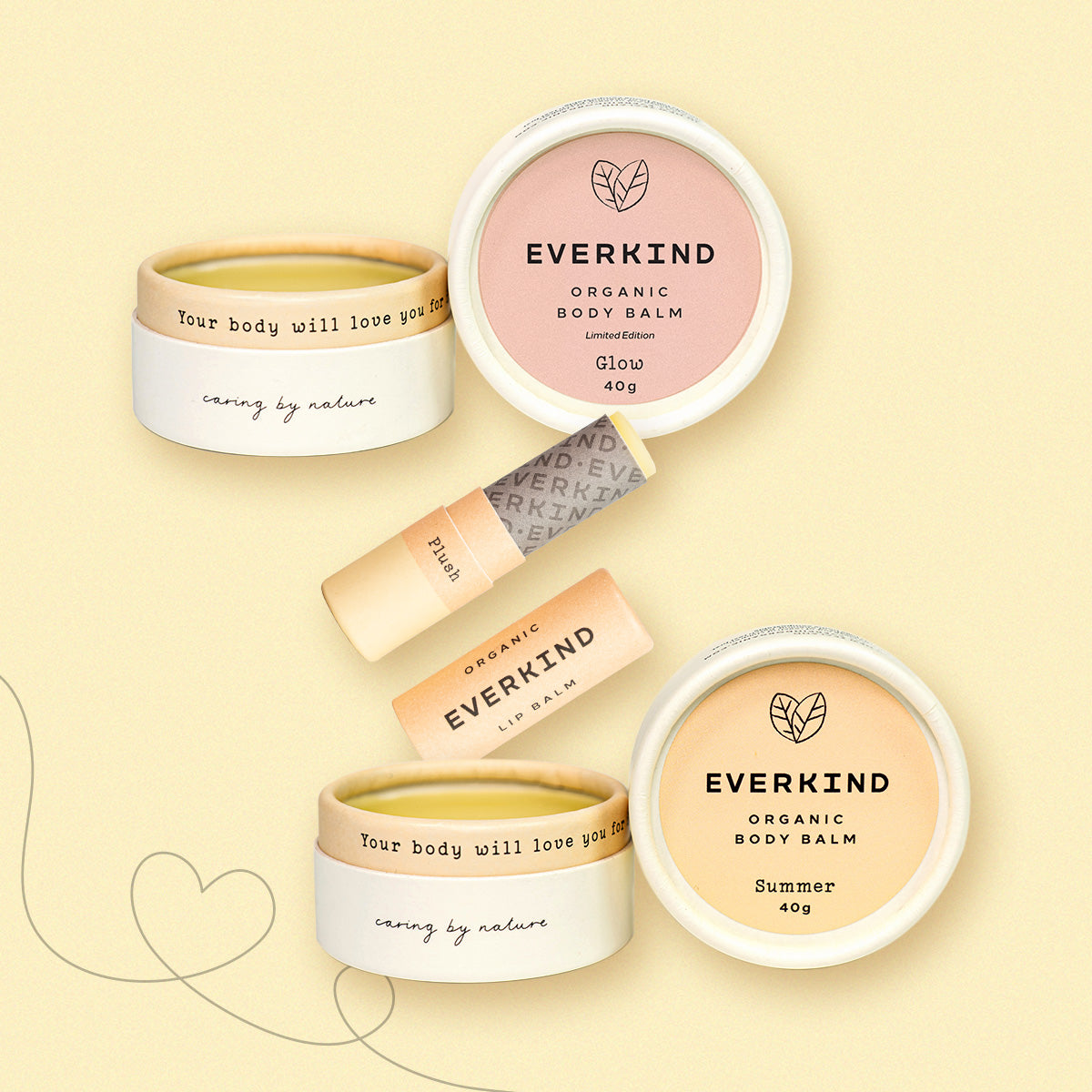 Flatlay of Everkind’s Little Luxuries Set, featuring Summer and Glow body balms and Plush lip balm, with heart illustrations on a soft yellow background.