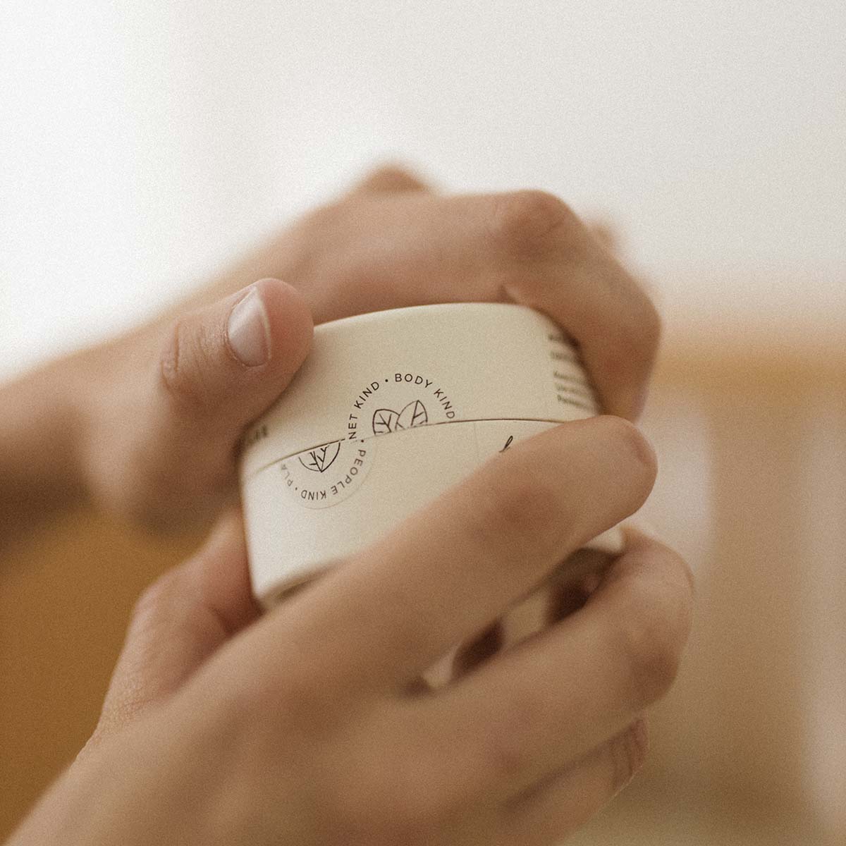 woman opening par jar of organic baby balm