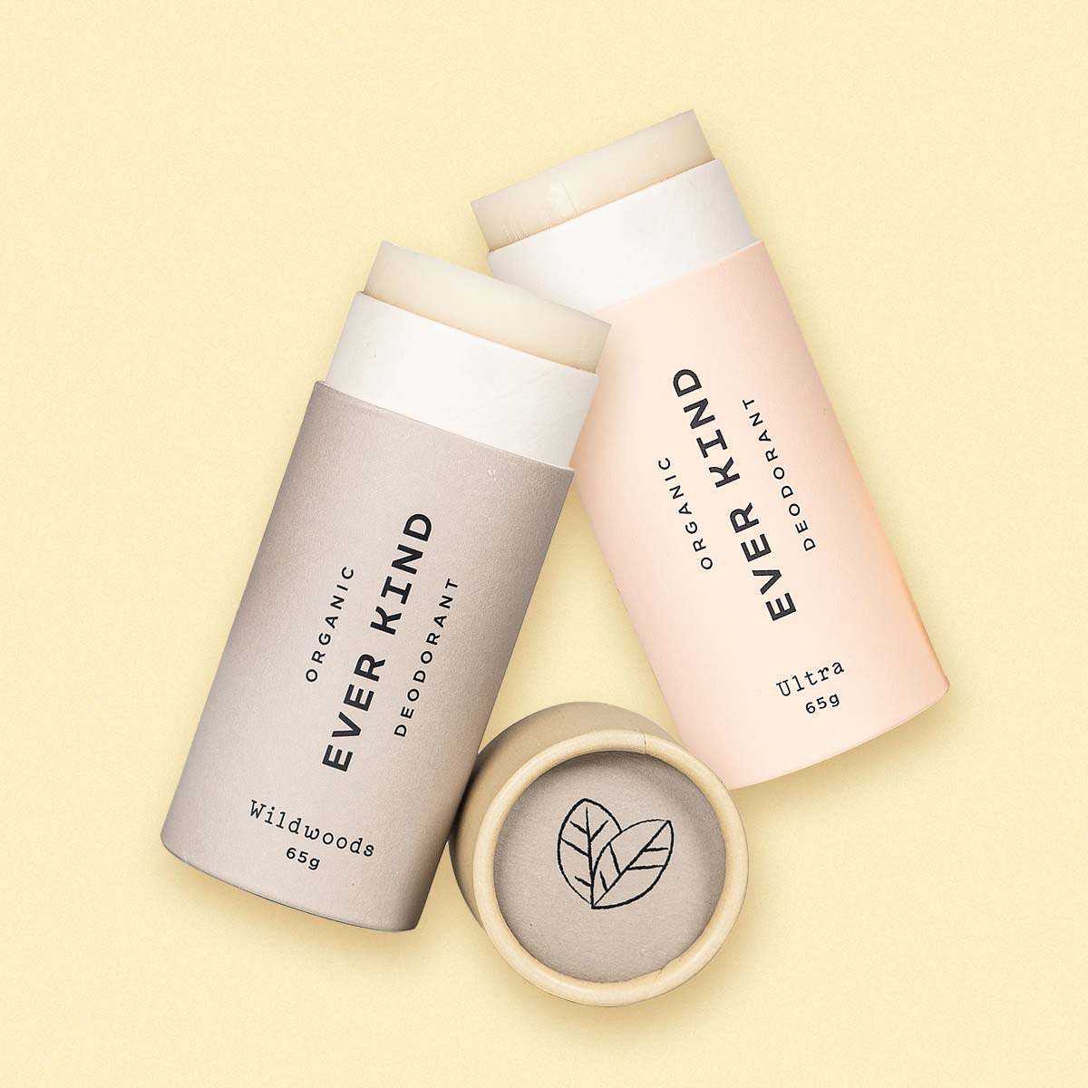 Everkind's his and hers deodorant set, featuring Ultra and Wildwoods natural deodorants in compostable paper packaging, laid flat on a soft yellow background.