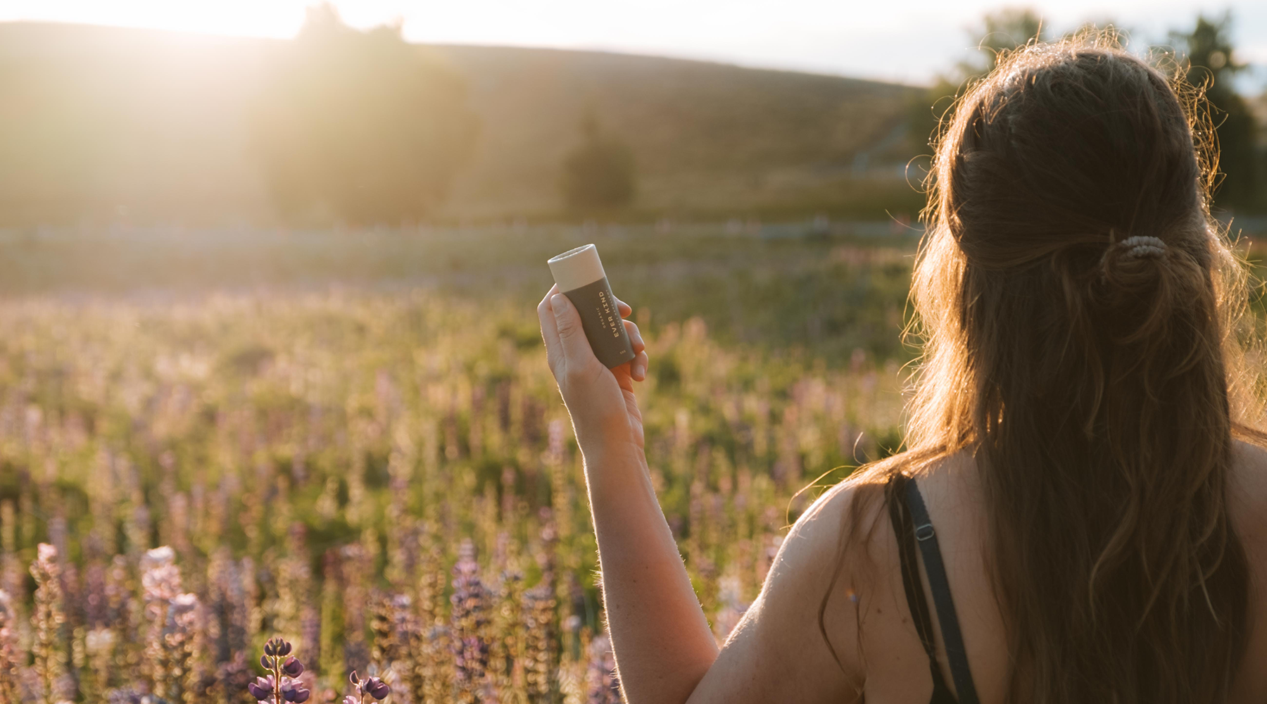 Woman adventuring in nature, protected by Everkind natural organic insect repellent.