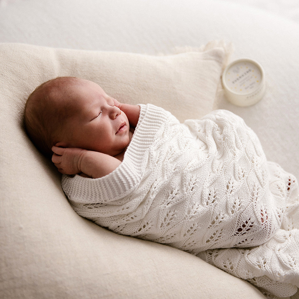 Photo of baby sleeping on back next to a jar of Everkind New Baby. This balm is perfect for baby massage and moisturising all over. Unscented and very gentle, it's the best skincare for a newborn.