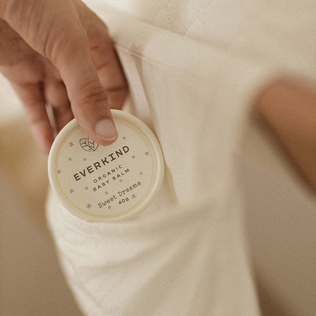 Woman placing baby's bedtime balm on the change table bag.